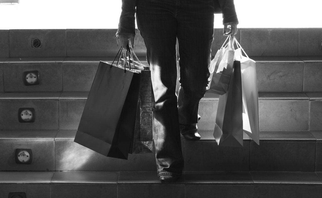 Person walking stairs with shopping bags copy