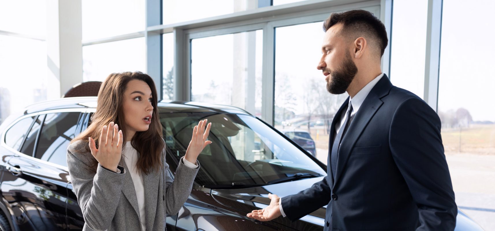 Saleswoman gesturing colleague car showroom