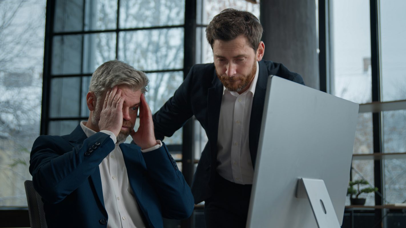 Two upset frustrated caucasian men businessmen coworkers looking computer screen office copy