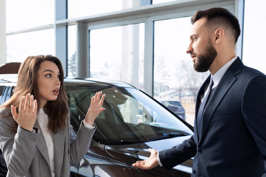 Saleswoman gesturing colleague car showroom