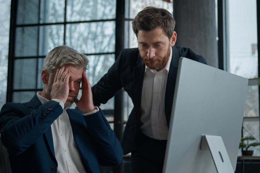 Two upset frustrated caucasian men businessmen coworkers looking computer screen office copy