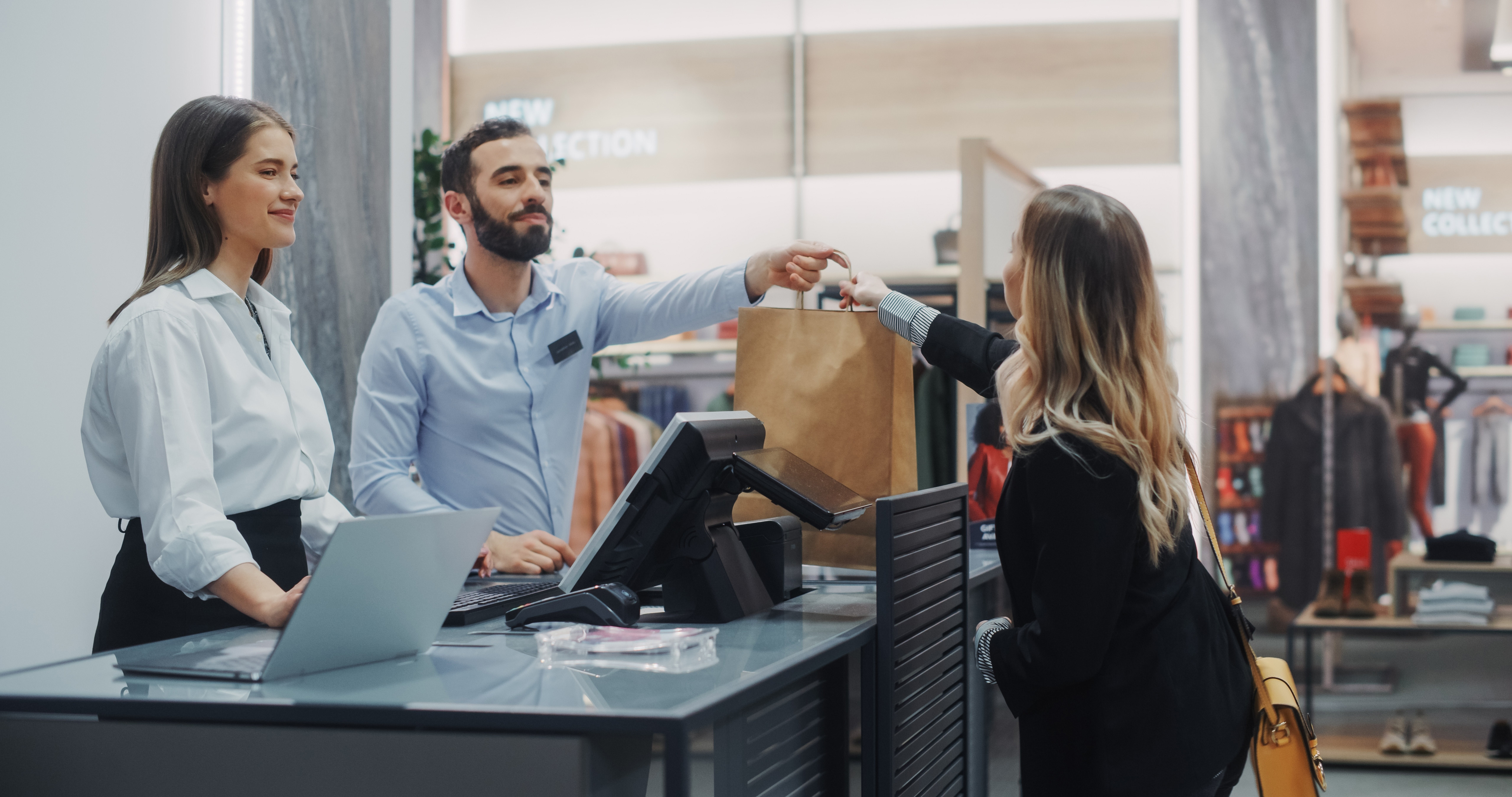 Clothing store checkout cashier counter beautiful young woman buys blouse from friendly retail sales assistant receiving bag with purchases trendy fashion shop with designer brands 1 copy