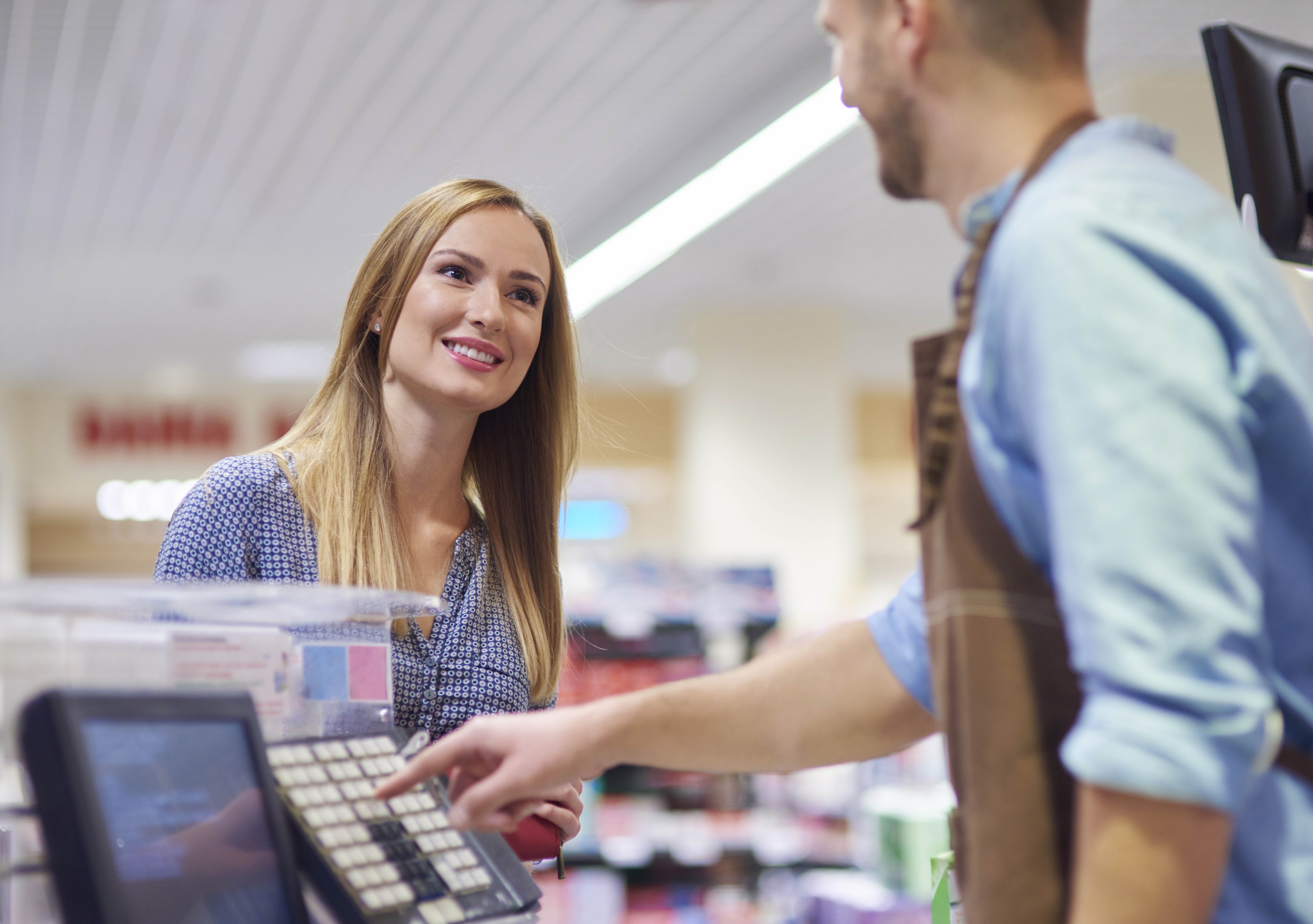 Woman cash register talking with sales clerk